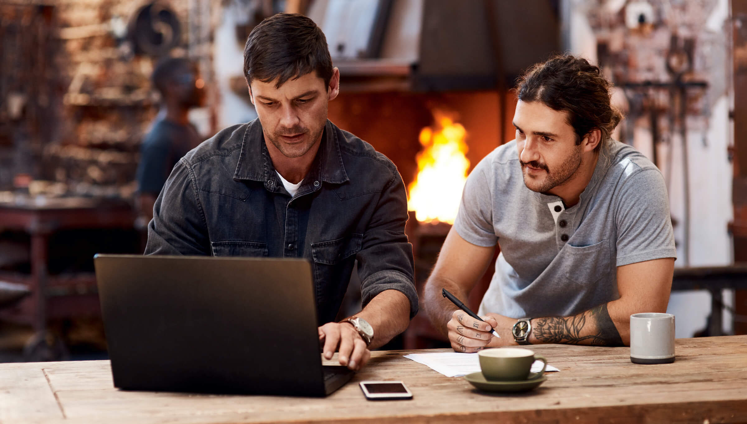 Two men discussing business loans on a computer