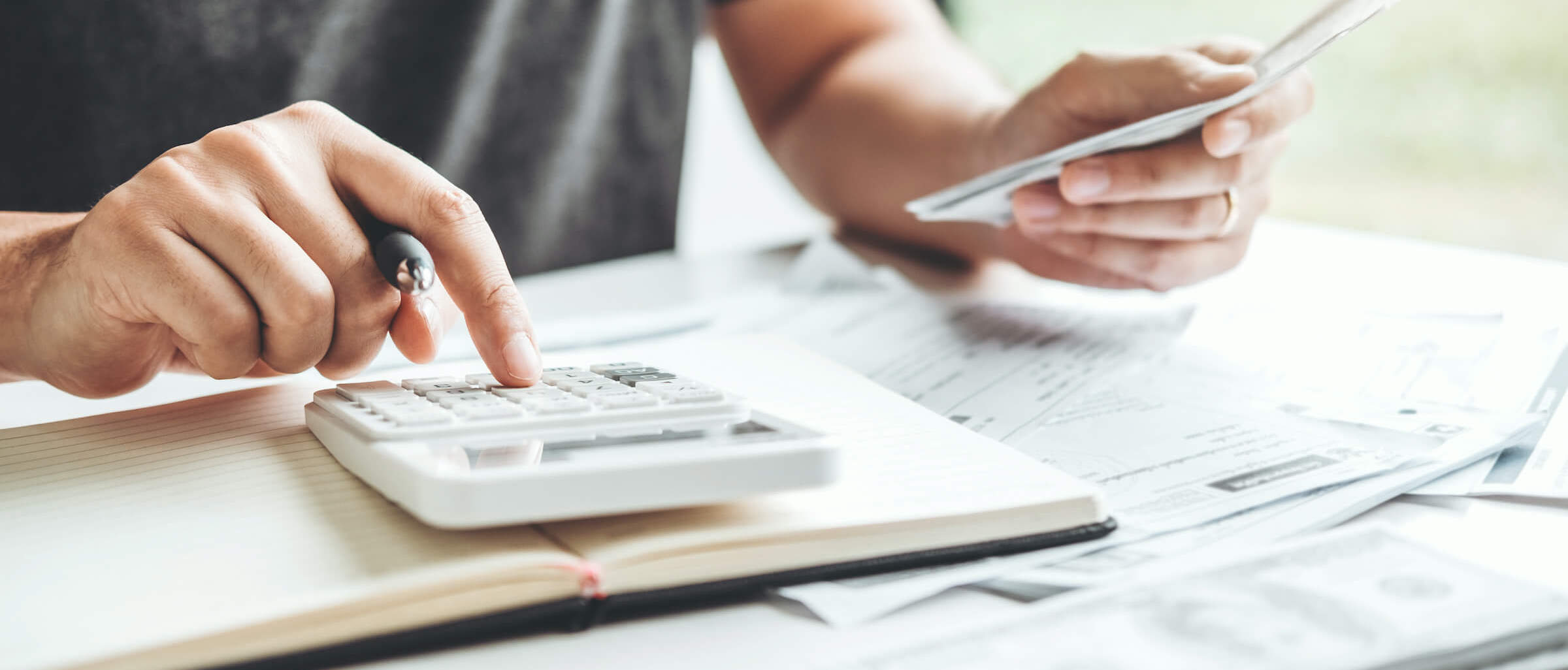 man using calculator to calculate invoice and finances