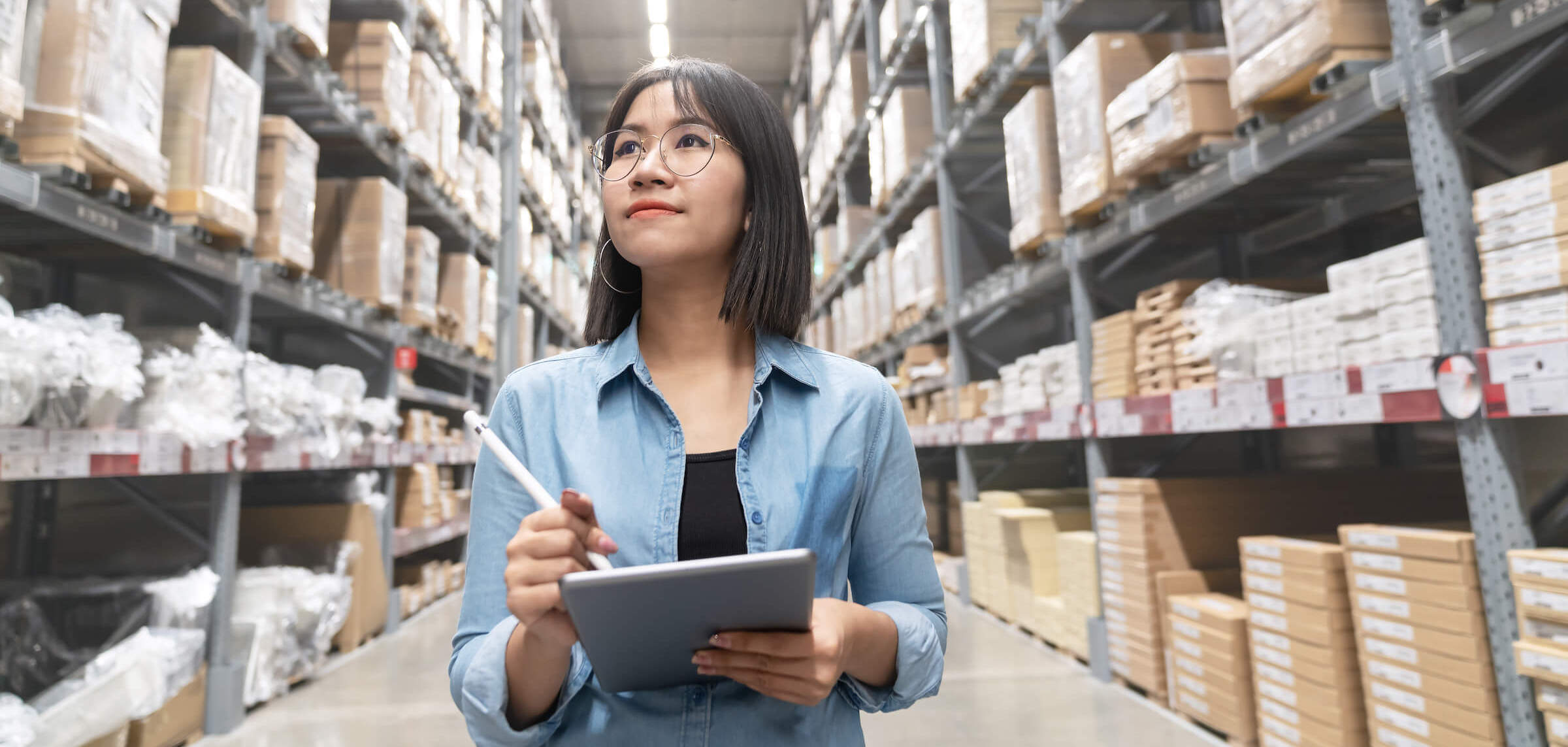 woman doing stocktake of large business supplies warehouse